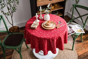 Detail of red Christmas tablecloth with golden snowflake patterns in a cozy dining room