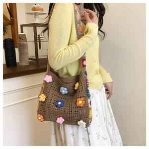 Detail of hand-crocheted sunflower bag with colorful floral appliques and boho strap