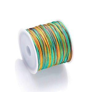 Macro shot of gradient colorful braided jewelry cord on white spool for DIY crafts