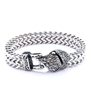 Detail of silver Viking wolf head clasp on a heavy stainless steel woven chain bracelet