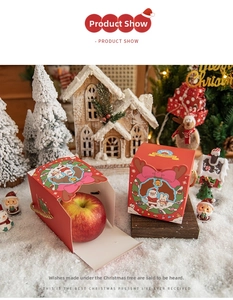 Close-up of red Christmas gift box with Santa motif and clear window holding a fresh apple