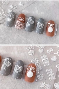 Detail of 3D white lace nail art stickers with embossed heart and bow patterns