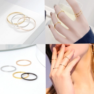 Detail shot of four minimalist slim rings in gold, silver, rose gold, and black colors
