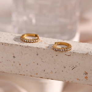 Macro detail of gold 18K plated hoop earrings featuring micro-paved white cubic zirconia