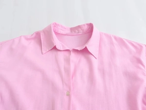 Close-up of a pink cotton oxford shirt showing the collar and button detail clearly