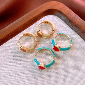 Detail of vintage enamel heart hoop earrings in beige and turquoise gold finishes
