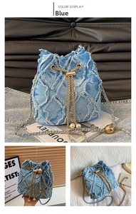 Detail of blue denim bucket bag featuring diamond quilting, frayed edges, and pearl accents