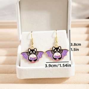 Detail view of cartoon cat earrings with wings and size specs on a white velvet display