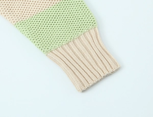 Close-up of ribbed cuffs and waffle knit texture on a striped off-shoulder sweater