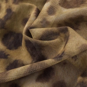 Macro detail of breathable leopard print mesh fabric with brown animal pattern