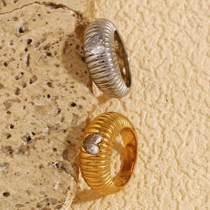 Close-up of heart-shaped zircon rings with unique twisted texture in gold and silver
