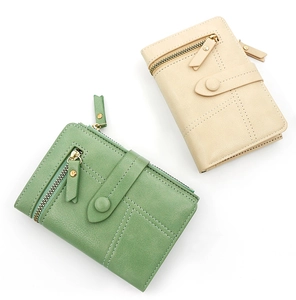 Detail of short tri-fold PU leather wallets in green and beige with clasp and zipper