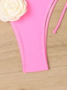 Detailed view of hot pink bikini bottoms with side ties and white 3D fabric flower