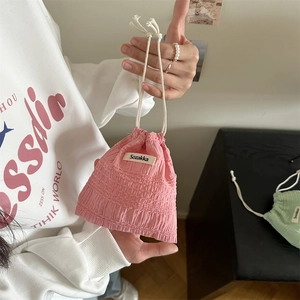 Detailed macro view of pink seersucker drawstring pouch with Sozakka brand woven label