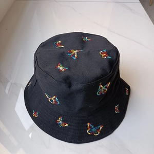 Nahaufnahme eines schicken schwarzen Fischerhutes mit lebhafter, bunter Schmetterlingsstickerei.
