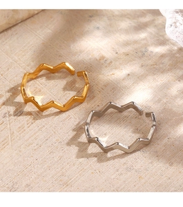 Detailed view of wavy 18K gold and silver plated open rings on a natural stone surface