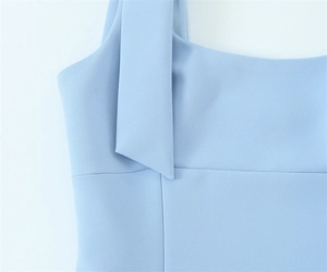 Detailed close-up of light blue top featuring square neckline and wide strap stitching