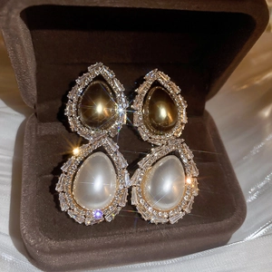 Boucles d'oreilles goutte dorées vintage avec perles et zircone sur fond de soie