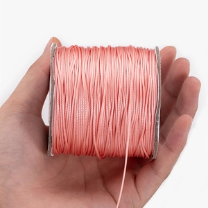 Pink Korean waxed cord roll held by hand for DIY necklace making and craft projects