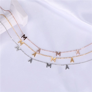 Three MAMA letter necklaces in gold silver and rose gold on white satin fabric