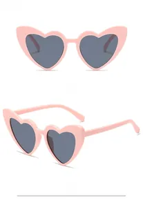 Front and side views of light pink heart-shaped sunglasses with dark tinted lenses