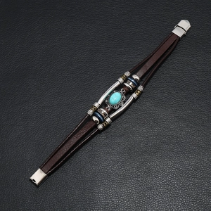 Multilayer leather bracelet with turquoise stones and metal beads on black texture