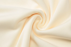 Close-up of the delicate beige lace fabric texture and elegant draped folds on the skirt