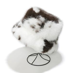 Detail of winter faux fur bucket hat with brown cow print on white fluffy material