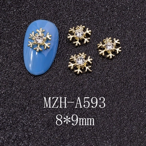 Macro shot of 8x9mm gold snowflake nail charms with crystal for Christmas manicure