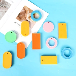 Flat lay of colorful macaron resin charms in geometric shapes with pre-drilled holes