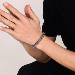 Dettaglio del bracciale punk a doppia serpente in argento antico da uomo