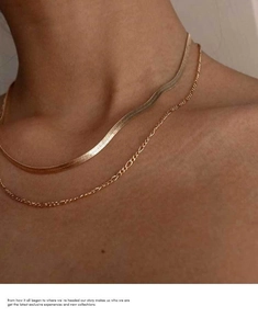 Detail view of double layered gold herringbone snake chain necklace on model neck