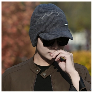 Detail of grey winter knit earflap cap featuring mountain pattern and warm fleece lining