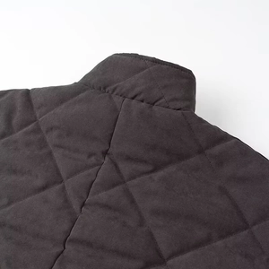 Detail of vintage quilted diamond pattern jacket with stand collar and dark fabric