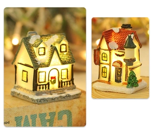 Close-up of lighted Nordic Christmas village houses with snowy roofs and dining sign