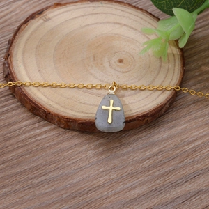 Minimalist stainless steel necklace featuring a cross on a natural grey stone pendant