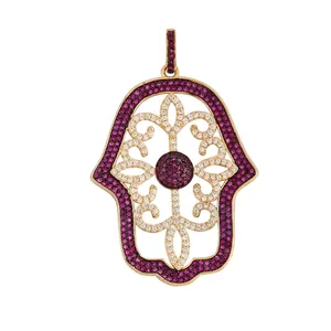Detailed close-up of golden Hamsa hand pendant with colorful gemstones and filigree