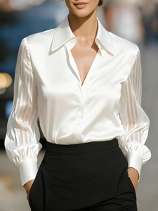 Detail of white satin shirt featuring puff sleeves and translucent striped chiffon texture