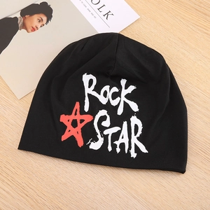 Detail van Rock STAR print en rode ster op zwarte gebreide zomer slaapmuts op hout