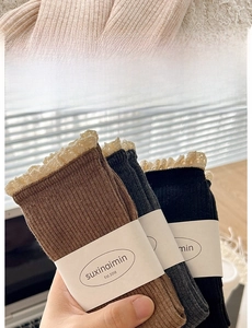 Detailed close-up of thick knitted cotton socks with white lace trim and elastic cuffs