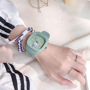 Close-up of mint green silicone watch featuring a cute cartoon elephant dial on wrist