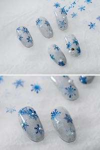 Detailed close-up of 5D blue snowflake nail stickers with pearls and glitter