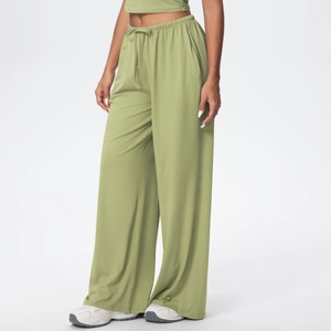 Detail of sage green wide-leg trousers showing soft fabric texture and drawstring waist