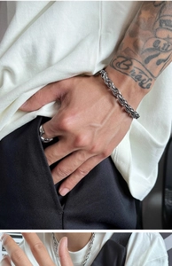 Close-up of a men's silver stainless steel twisted curb chain bracelet on wrist