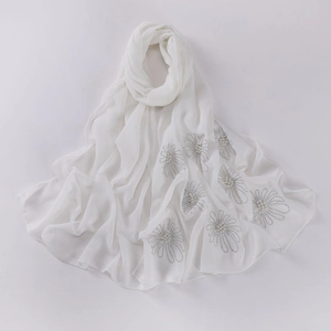 Close-up of white chiffon hijab with exquisite silver bead and pearl flower patterns