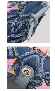 Detail of pink star patch embroidery and silver metal twist lock on blue denim bag