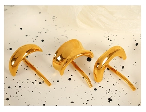 Detailed macro view of three curved gold-plated stainless steel hair clips for styling