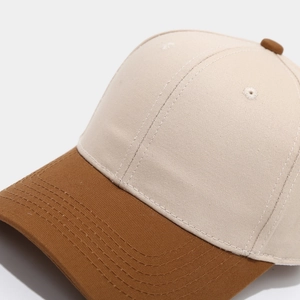Detail of two-tone cotton baseball cap showing contrast brim stitching and eyelet