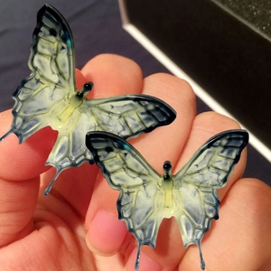 Gros plan détaillé de pendentifs papillon en résine dégradé bleu et jaune avec marbrures