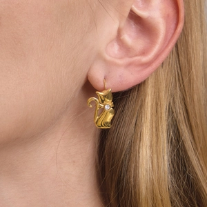 Elegant gold cat-shaped stainless steel earrings with white zircon on a model